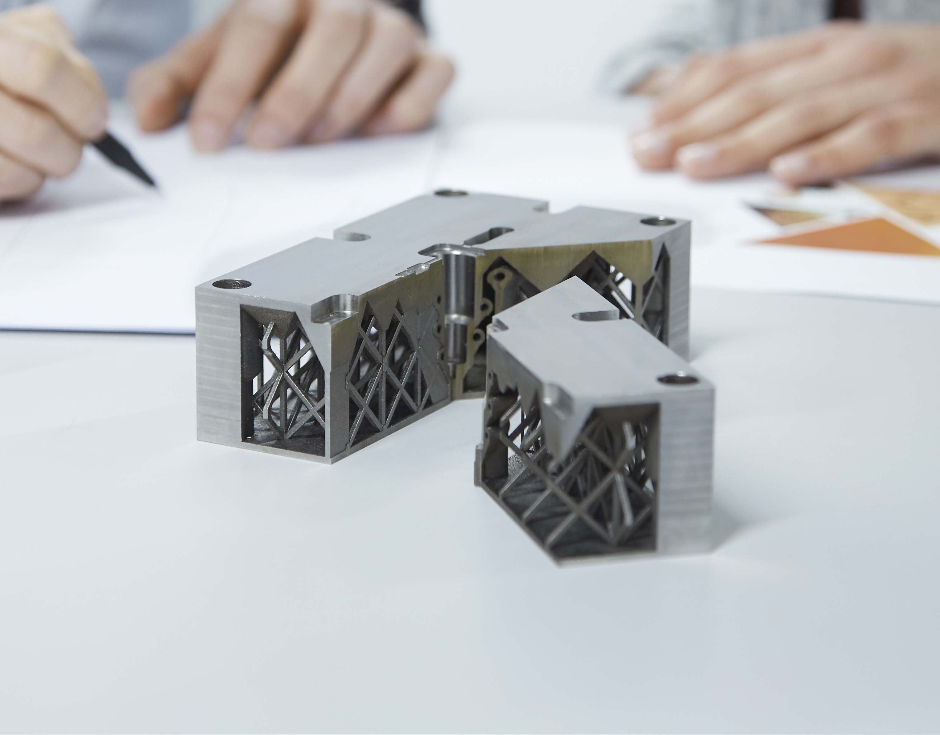 3D-Objekt aus Metall vor Arbeitsskizzen